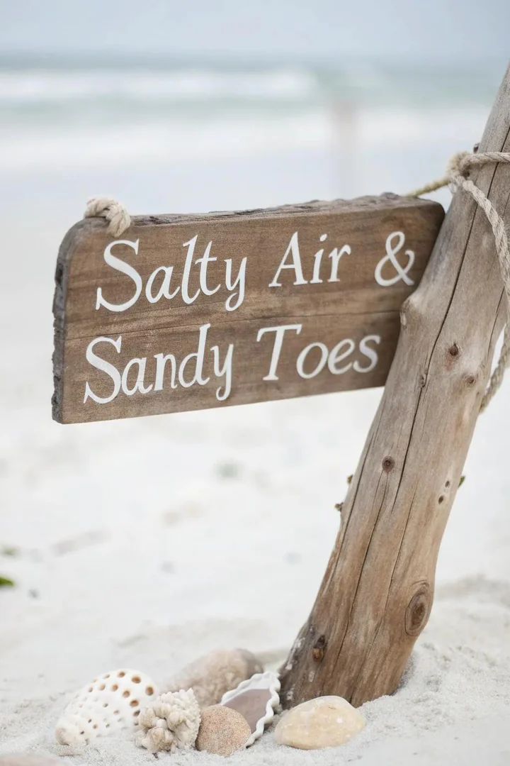 Bring the coast home with this charming handmade sign that whispers 'Salty Air & Sandy Toes.'